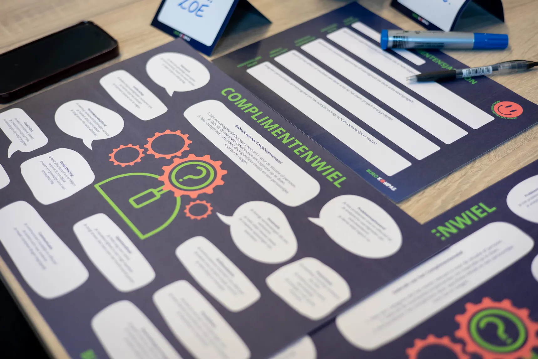 Werkplezier-activiteit met kleurrijke verbindingsoefeningen en teambuilding-kaarten op een bord