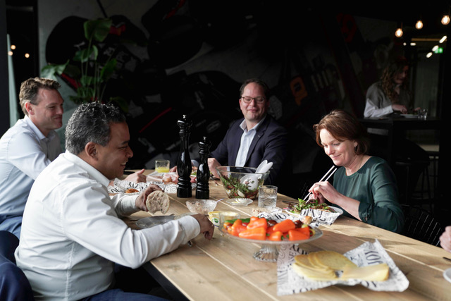 Groep professionals tijdens workshop kernwaarden, discussie aan tafel met eten en drinken
